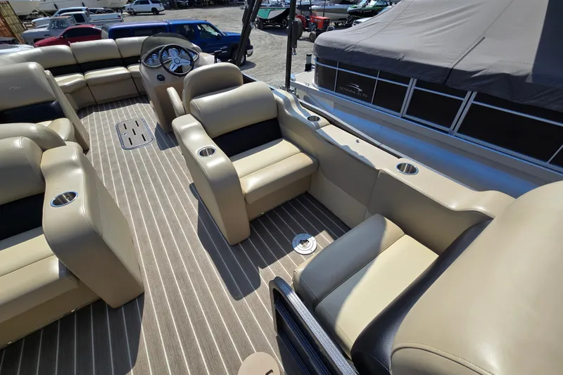 Slide: The Image of 2016 Manitou 23 Oasis SR pontoon boat interior with beige seating and striped flooring. - 12