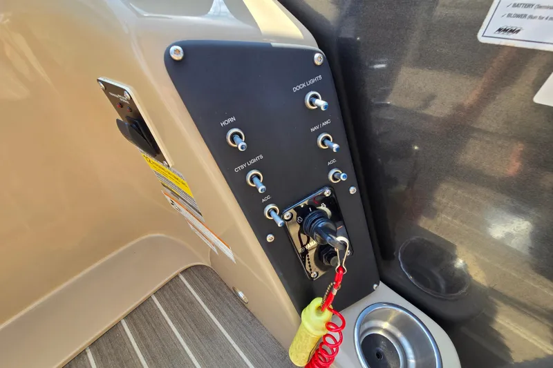 Slide: The Image of Control panel of a 2016 Manitou 23 Oasis SR boat with switches and ignition key. - 33