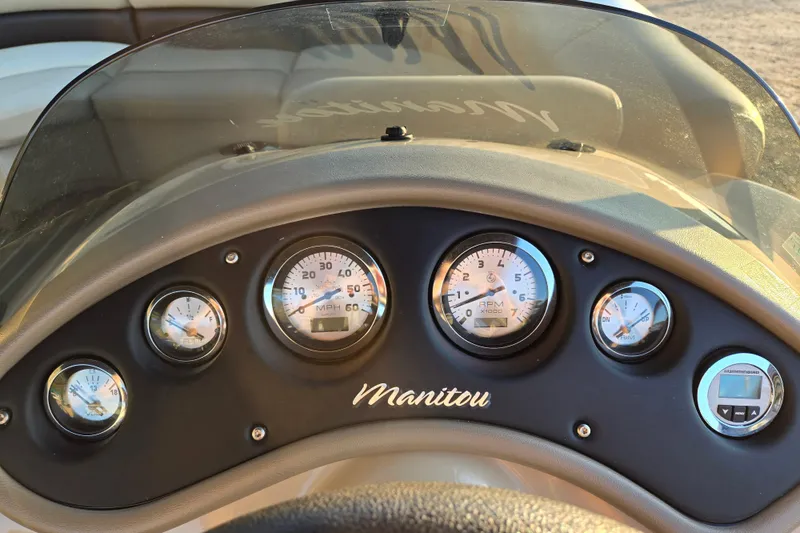 Slide: The Image of Dashboard of a 2016 Manitou 23 Oasis SR boat with gauges and controls. - 32