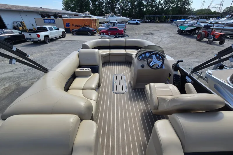 Slide: The Image of 2016 Manitou 23 Oasis SR pontoon boat interior with beige seating and steering console. - 15