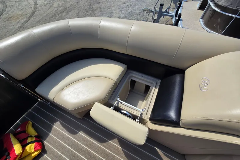 Slide: The Image of 2016 Manitou 23 Oasis SR boat interior with beige seating and storage compartment. - 22