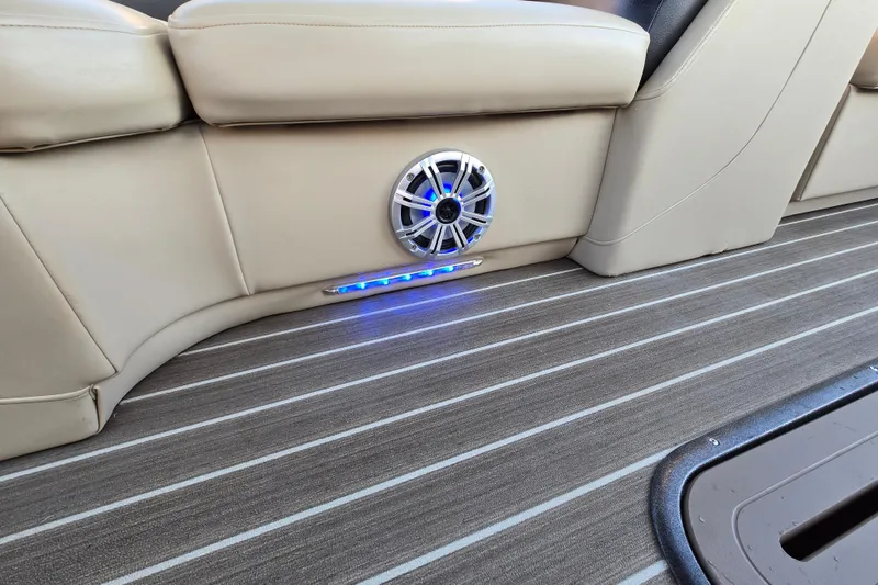 Slide: The Image of Interior of 2016 Manitou 23 Oasis SR with beige seating, speaker, and blue LED lighting. - 37