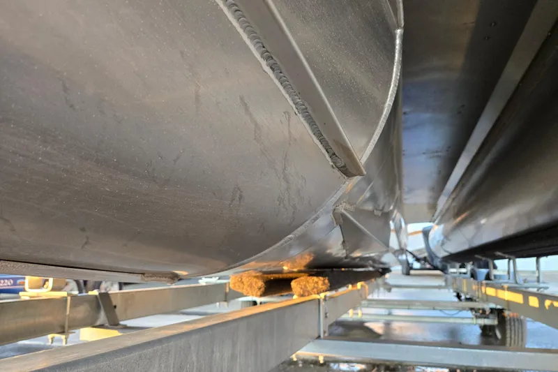 Slide: The Image of Underneath view of a 2016 Manitou 23 Oasis SR pontoon boat on a trailer. - 8