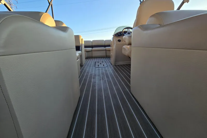 Slide: The Image of Interior view of 2016 Manitou 23 Oasis SR pontoon boat with beige seating and striped flooring. - 24
