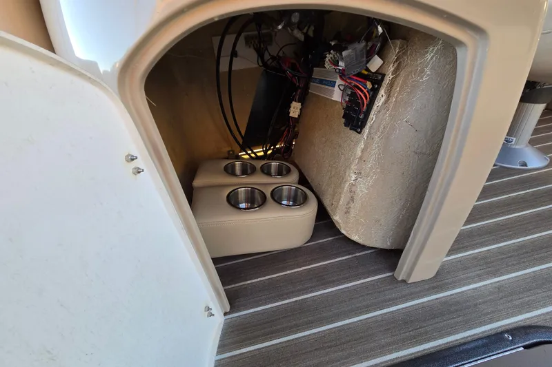 Slide: The Image of Interior view of a 2016 Manitou 23 Oasis SR boat showing cup holders and wiring. - 36