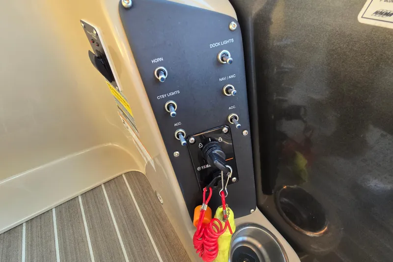 Slide: The Image of Control panel of a 2016 Manitou 23 Oasis SR boat with switches and key ignition. - 26