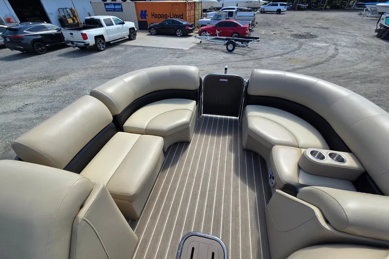 Slide: The Image of 2016 Manitou 23 Oasis SR pontoon boat interior with beige seating and striped flooring. - 17