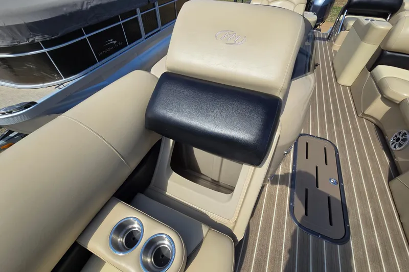 Slide: The Image of Interior of 2016 Manitou 23 Oasis SR boat with beige seating and cup holders. - 21