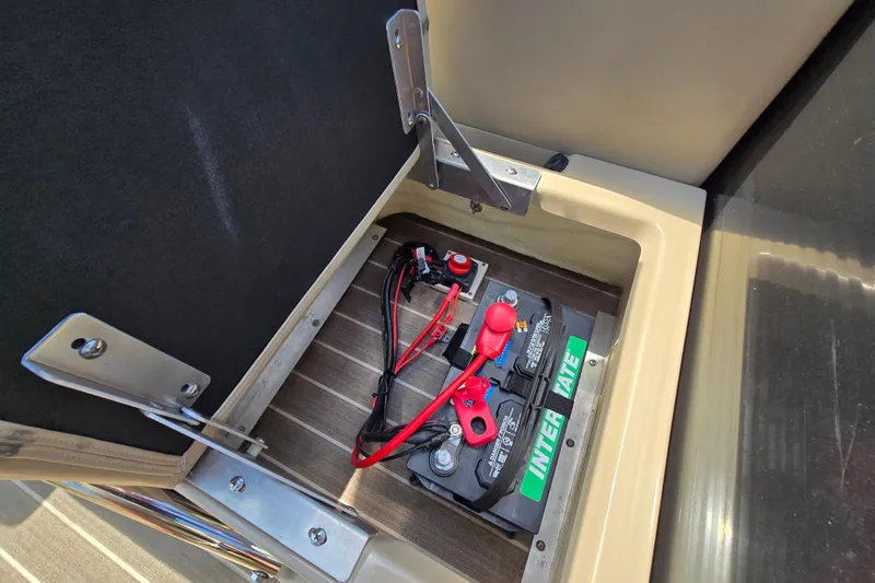 Slide: The Image of Battery compartment of a 2016 Manitou 23 Oasis SR boat, featuring an Interstate battery. - 44