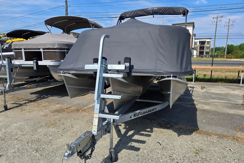 Slide: The Image of 2016 Manitou 23 Oasis SR pontoon boat on trailer, covered and parked outdoors. - 3