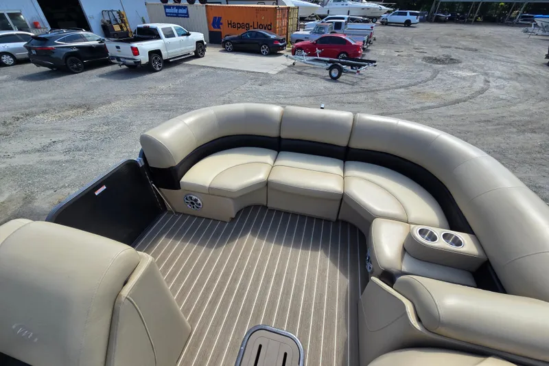 Slide: The Image of 2016 Manitou 23 Oasis SR pontoon boat interior with beige seating and striped flooring. - 16
