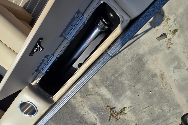Slide: The Image of An open storage compartment in a boat with a black pipe and a silver latch. - 23