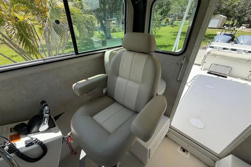 Slide: The Image of Captain's chair inside 2016 Parker 2820 XLD Sport Cabin, with control panel and outdoor view. - 19