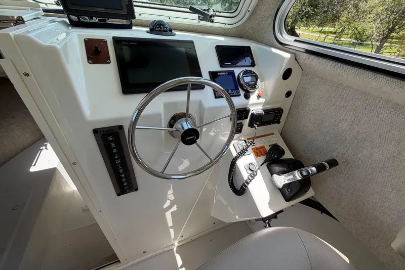 Slide: The Image of 2016 Parker 2820 XLD Sport Cabin helm with steering wheel and navigation controls. - 18