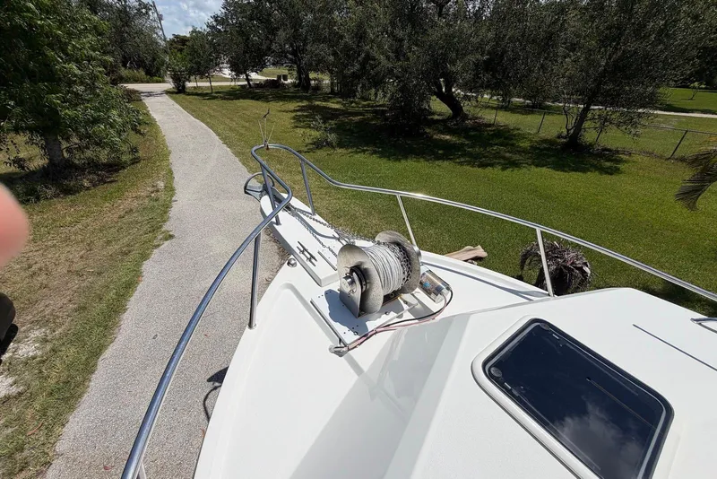Slide: The Image of 2016 Parker 2820 XLD Sport Cabin boat deck with anchor winch, surrounded by lush greenery. - 10