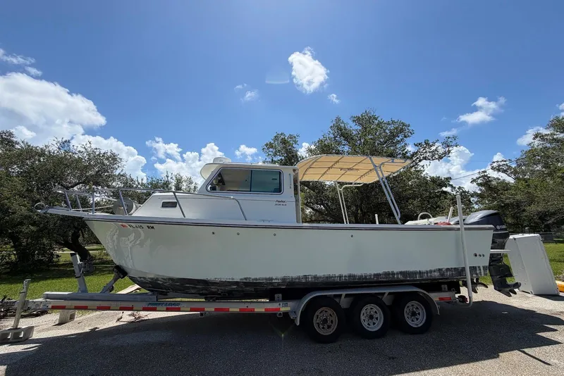 Slide: The Image of 2016 Parker 2820 XLD Sport Cabin boat on trailer under clear blue sky. - 1