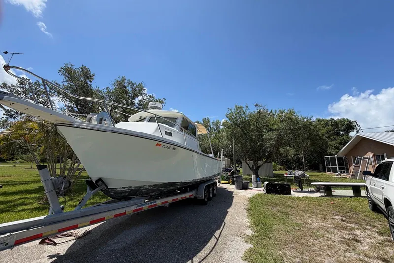 Slide: The Image of 2016 Parker 2820 XLD Sport Cabin boat on trailer in sunny yard setting. - 4