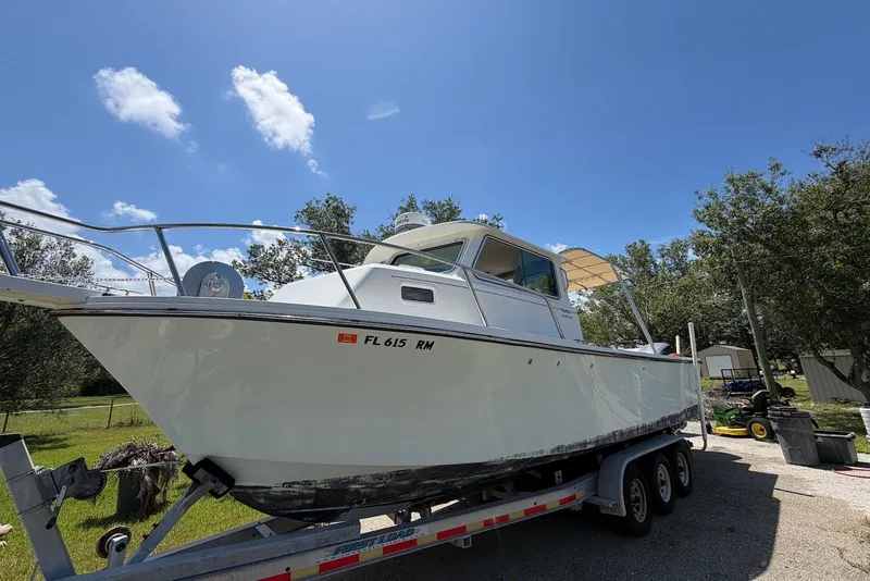 Slide: The Image of 2016 Parker 2820 XLD Sport Cabin boat on trailer under clear blue sky. - 2