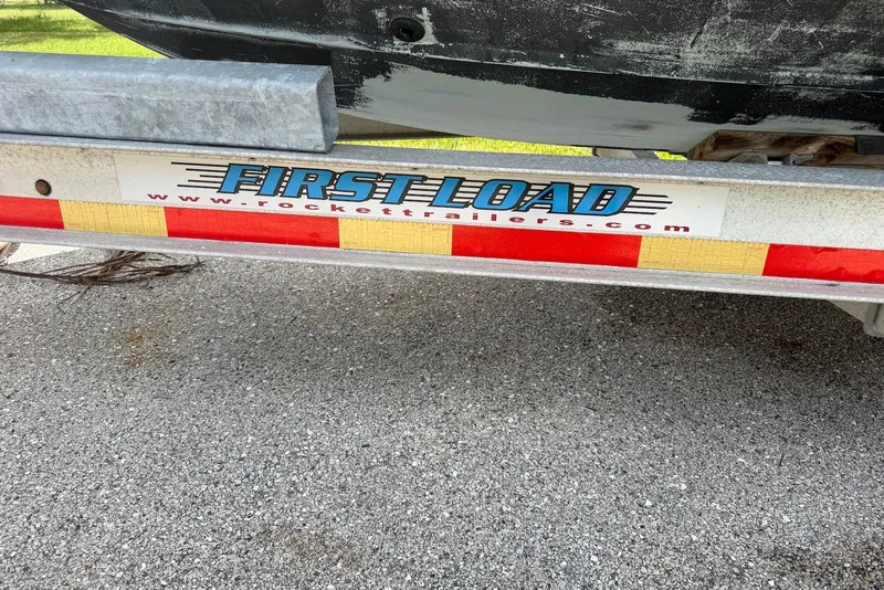 Slide: The Image of Trailer with "First Load" branding, supporting a 2016 Parker 2820 XLD Sport Cabin boat. - 23