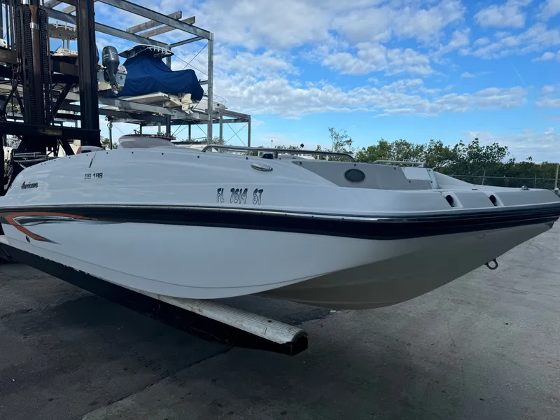 Slide: The Image of 2021 Hurricane 188 SunDeck Sport -OB on a dry dock, with blue sky in the background. - 2
