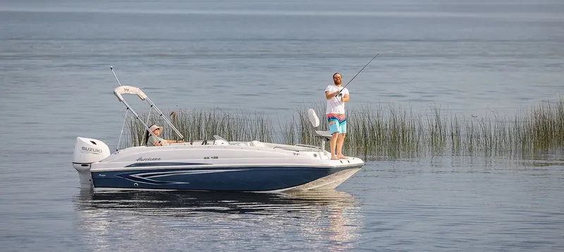 Slide: The Image of 2021 Hurricane 188 SunDeck Sport -OB on calm water with two people, one fishing. - 13