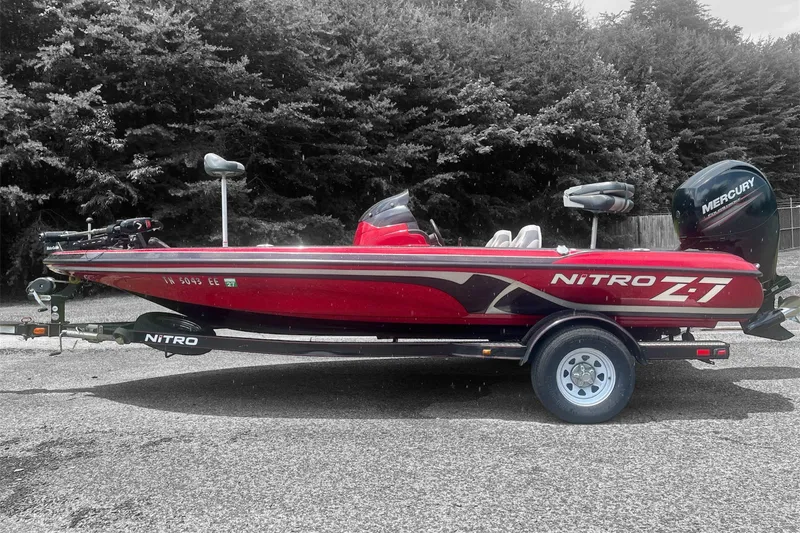 The Image of Red 2013 Nitro Z-6 boat with Mercury engine on trailer, parked outdoors. - 0