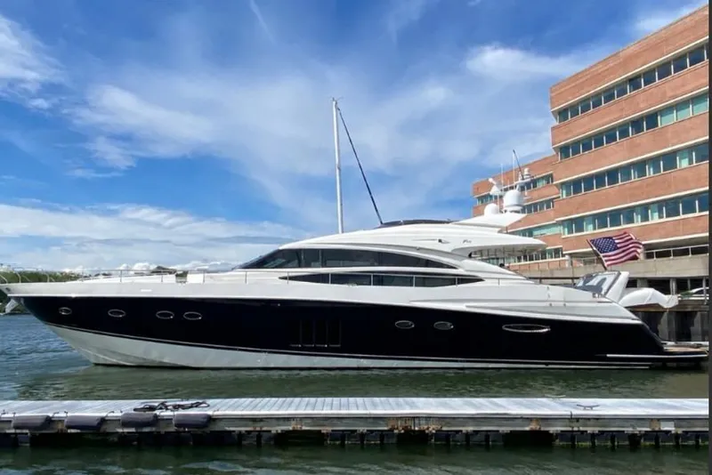 The Image of 2009 Princess 85 Motor Yacht docked beside a modern building under a clear blue sky. - 0