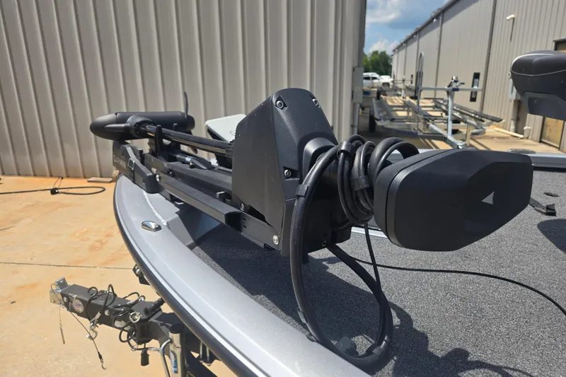 Slide: The Image of 2023 Vexus AVX1980C boat with mounted trolling motor, parked outdoors. - 23