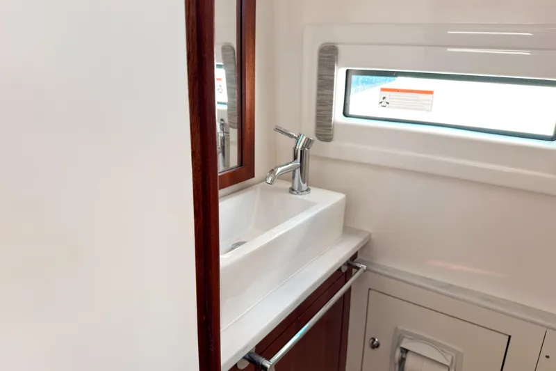 Slide: The Image of 2023 Pursuit S 378 Sport boat bathroom with sink, mirror, and window. - 12