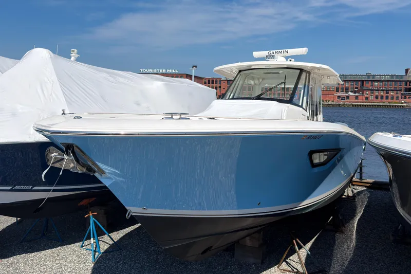 The Image of 2023 Pursuit S 378 Sport boat docked near water, showcasing sleek design. - 0