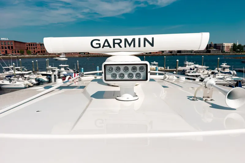 Slide: The Image of 2023 Pursuit S 378 Sport boat with Garmin radar, docked at a marina under clear skies. - 9