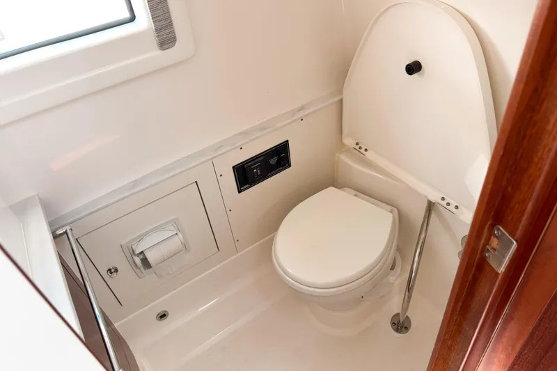 Slide: The Image of 2023 Pursuit S 378 Sport boat bathroom interior with toilet and window. - 13