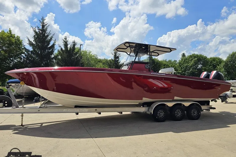 Slide: The Image of 2005 Fountain 34 Sportfish CC Open Bow boat on trailer, red hull, sunny day. - 20