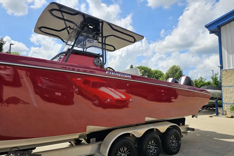 Slide: The Image of 2005 Fountain 34 Sportfish CC Open Bow boat on trailer, red hull, sunny day. - 21