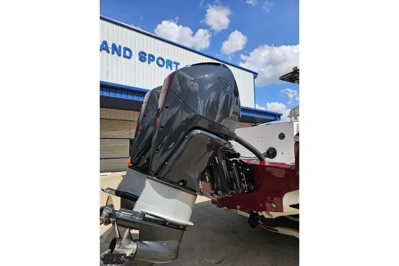 Slide: The Image of 2005 Fountain 34 Sportfish CC Open Bow with powerful outboard motor, parked near a building. - 36