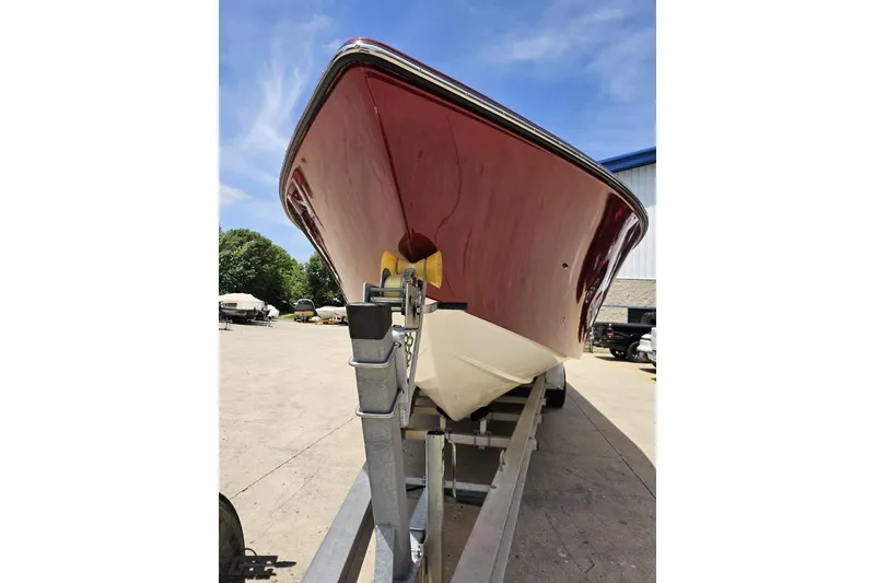 Slide: The Image of 2005 Fountain 34 Sportfish CC Open Bow on trailer, red hull, outdoor setting. - 16