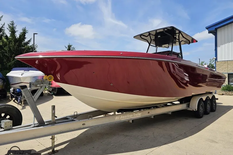 Slide: The Image of 2005 Fountain 34 Sportfish CC Open Bow boat on trailer, red hull, sunny day. - 18