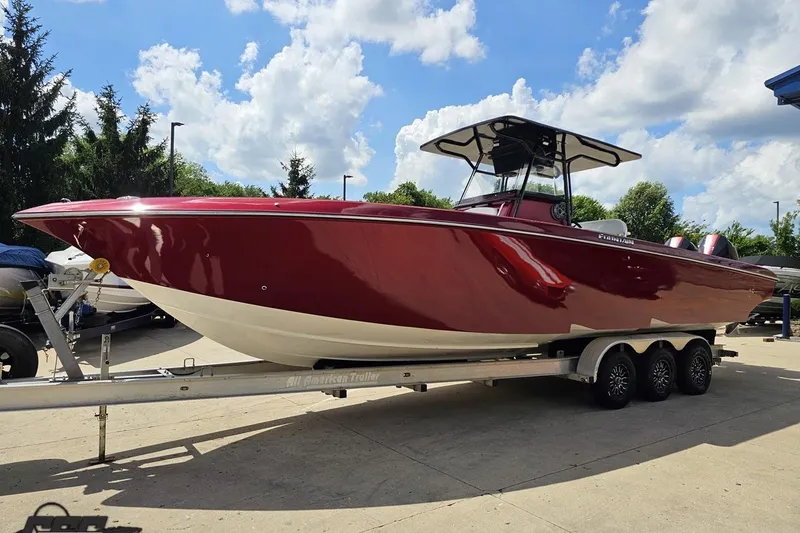 Slide: The Image of 2005 Fountain 34 Sportfish CC Open Bow boat on trailer, red hull, sunny day. - 19