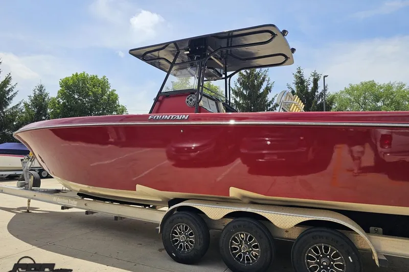Slide: The Image of 2005 Fountain 34 Sportfish CC Open Bow boat on trailer, red hull, sunny day. - 24