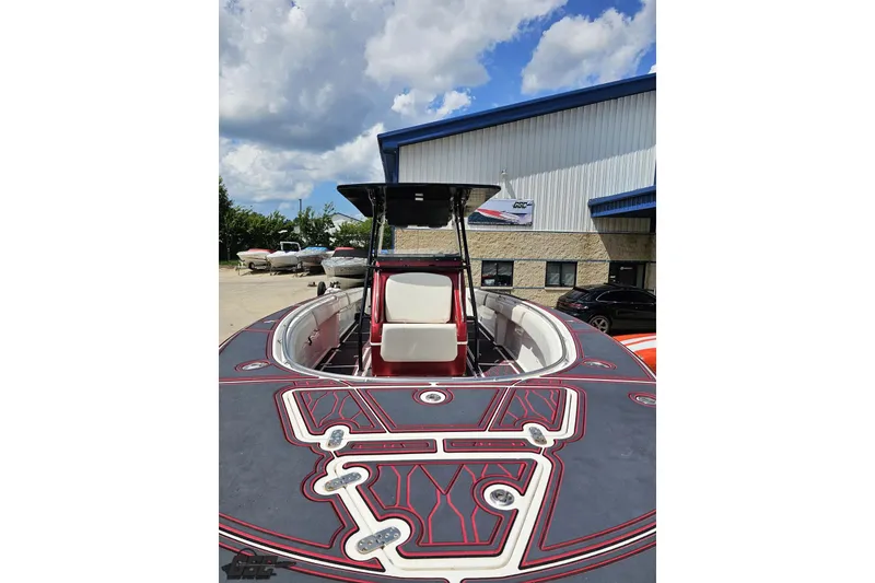 Slide: The Image of 2005 Fountain 34 Sportfish CC Open Bow boat with custom deck design, parked outdoors. - 15