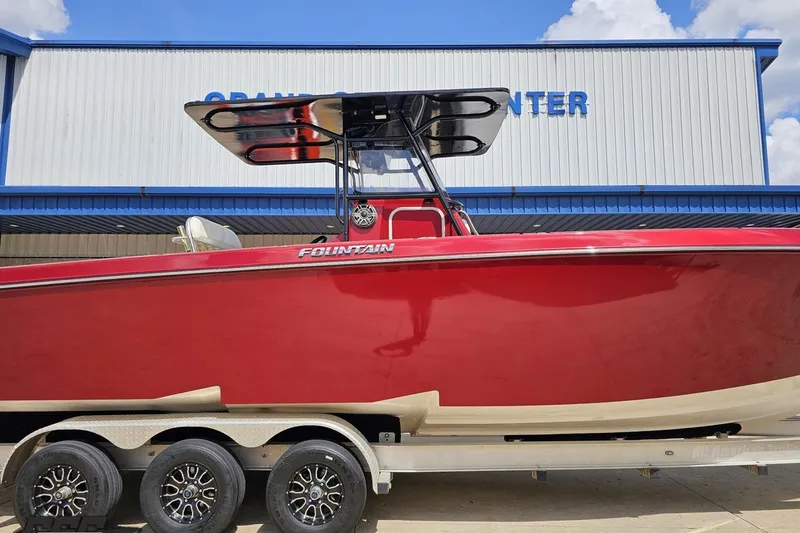 Slide: The Image of Red 2005 Fountain 34 Sportfish CC Open Bow boat on trailer, parked outside a building. - 3
