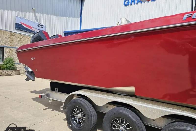 Slide: The Image of Red 2005 Fountain 34 Sportfish CC Open Bow boat on a trailer outside a building. - 7
