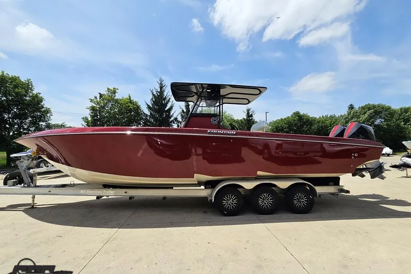 Slide: The Image of 2005 Fountain 34 Sportfish CC Open Bow boat on trailer, under clear blue sky. - 22
