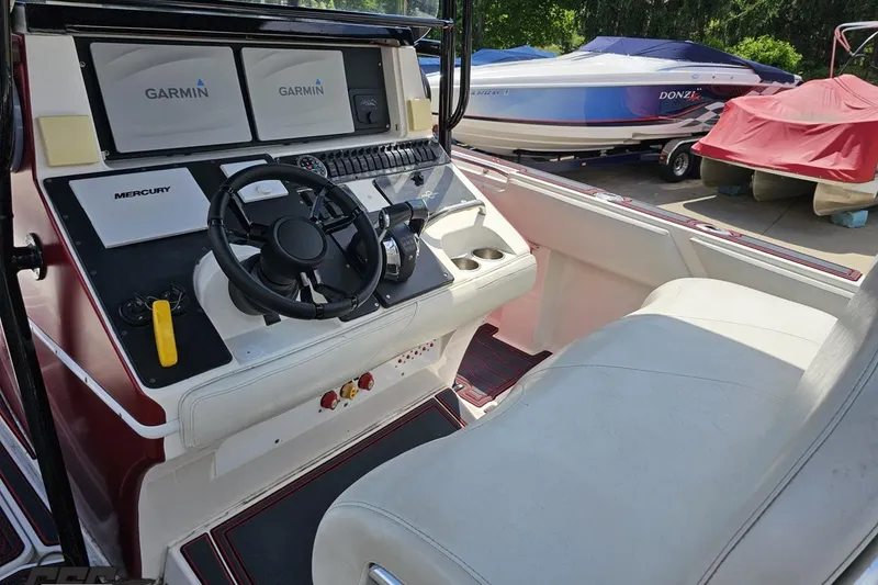 Slide: The Image of 2005 Fountain 34 Sportfish CC Open Bow boat cockpit with Garmin displays and Mercury controls. - 67
