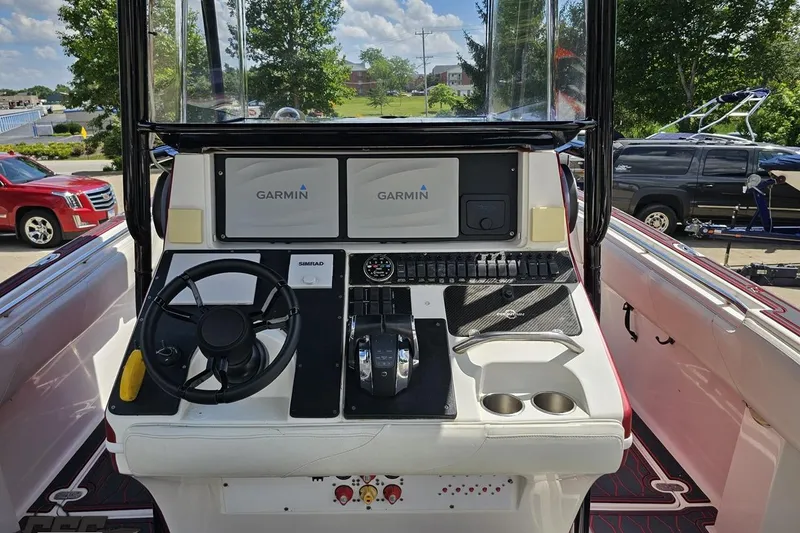 Slide: The Image of 2005 Fountain 34 Sportfish CC Open Bow boat dashboard with Garmin displays and steering wheel. - 59