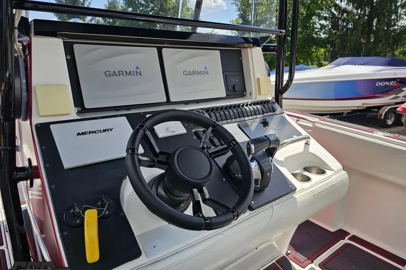 Slide: The Image of 2005 Fountain 34 Sportfish CC Open Bow boat dashboard with Garmin navigation and Mercury controls. - 68