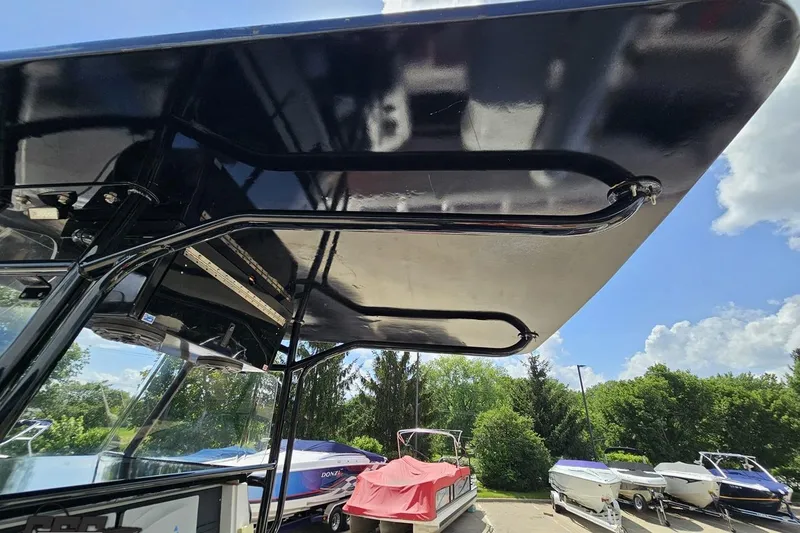 Slide: The Image of 2005 Fountain 34 Sportfish CC Open Bow boat with sleek black canopy and surrounding boats. - 72
