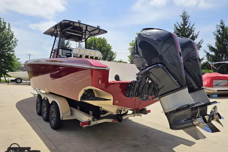 Slide: The Image of 2005 Fountain 34 Sportfish CC Open Bow boat with dual outboard motors on a trailer. - 27