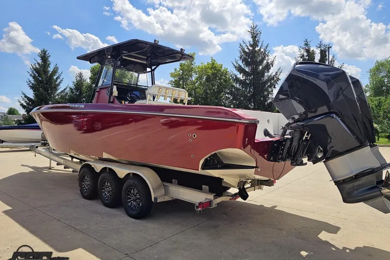 Slide: The Image of 2005 Fountain 34 Sportfish CC Open Bow boat on trailer, under clear blue sky. - 26