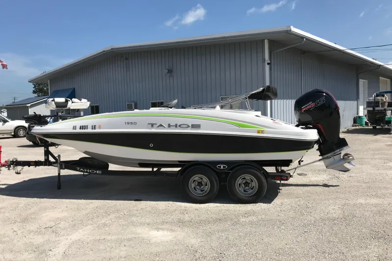 Slide: The Image of 2021 Tahoe 1950 boat on trailer, parked outside a metal building under a clear sky. - 4